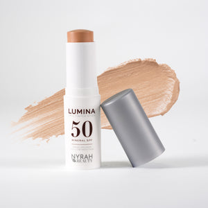 Nyrah Beauty Lumina 50 Mineral SPF stick sunscreen with its cap off, displayed next to a swipe of the beige-tan cream formula on a clean white background.