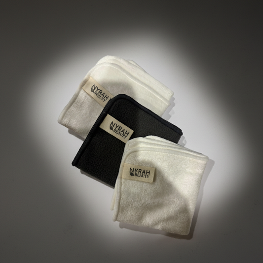 Three folded bamboo face cloths with 'Nyrah' branding on a gray background